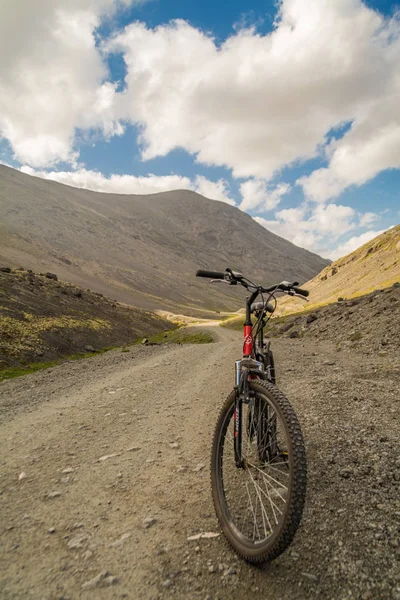 Красный велосипед на горной дороге — стоковое фото
