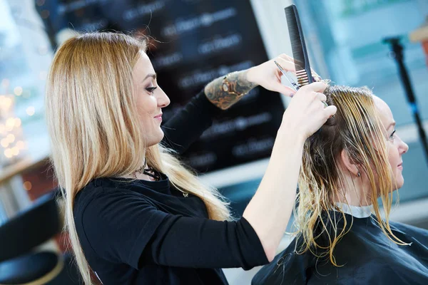 Friseur oder Stylist bei der Arbeit. Friseur schneidet Frau die Haare — Stockfoto