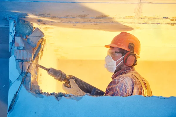 Trabajador con martillo de demolición rompiendo la pared interior —  Fotos de Stock