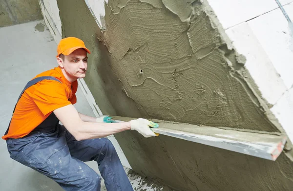 Gipser glättet frischen Putz an der Wand mit Richtkelle — Stockfoto