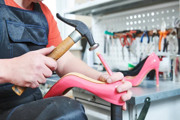 Skomakare reparera kvinnliga spike sko. Hamrande spets på hälen — Stockfoto
