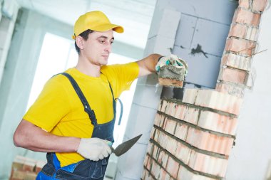 örmek. Tuğla duvar döşeme inşaat işçisi