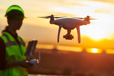Drone muayene. Uçağı ile uçan site bina inşaat teftiş işleç. günbatımı