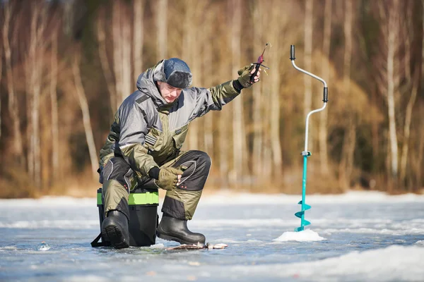 Pesca invernale sul ghiaccio. pescatore o pescatore agganciare il pesce — Foto Stock