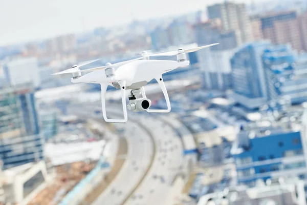 带着数码相机在城市上空盘旋的无人机 — 图库照片