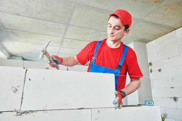 Afbakenen. metselaar installeren gesteriliseerde met autoclaaf belucht betonblokken. — Stockfoto