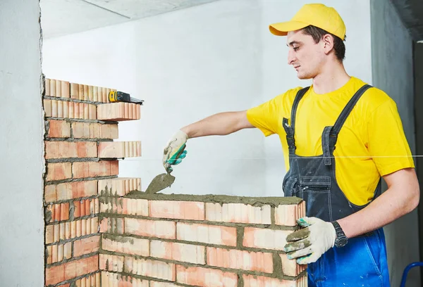 Bricklayingen. Byggnadsarbetare bygga en tegelvägg — Stockfoto
