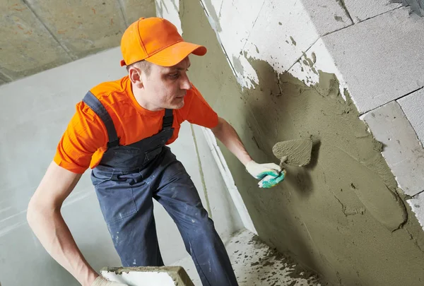 Renovação em casa. Estucador espalhando gesso na parede . — Fotografia de Stock