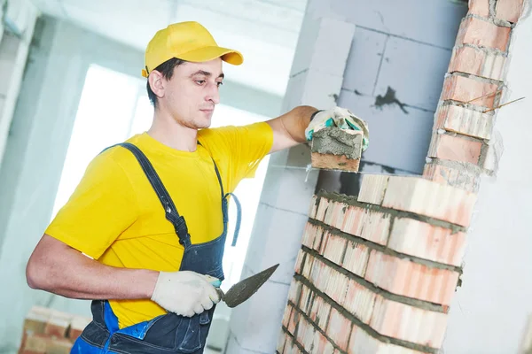 Metselen. Bouw werknemer legdatum bakstenen muur — Stockfoto