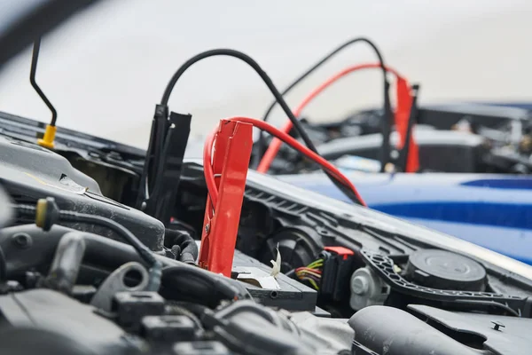 Ayuda automovilística. cables de puente de refuerzo cargando la batería descargada del automóvil —  Fotos de Stock