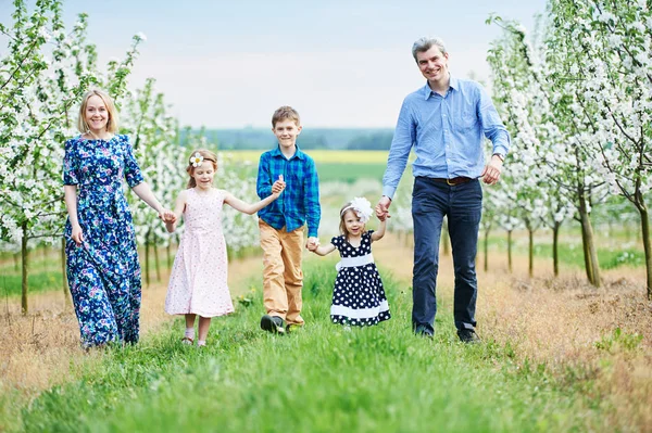 Grande família ao ar livre. Três crianças e pais no jardim florescendo da primavera — Fotografia de Stock