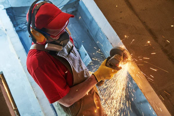 Renovering. arbetare skära metall armering stång i dörröppningen av kvarnen — Stockfoto