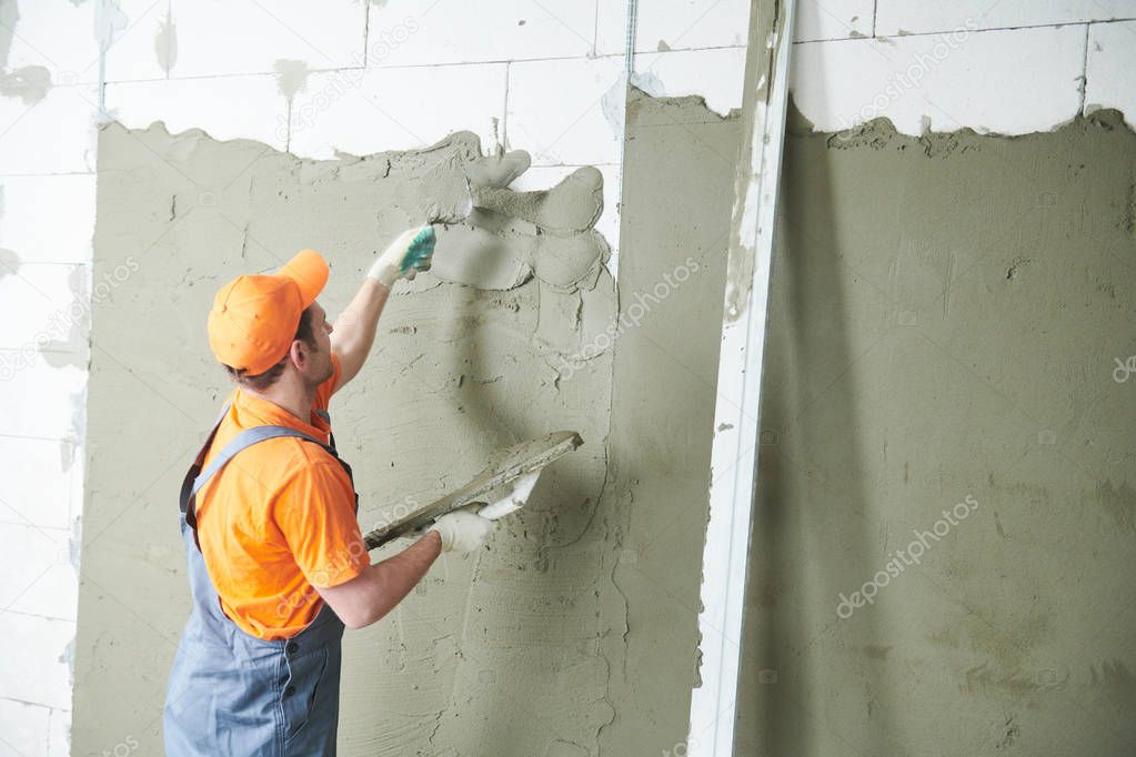 Plasterer spreading plaster on wall. Renovation service