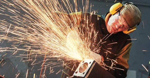 Worker grinding weld seam with grinder machine and sparks — Stock Photo, Image