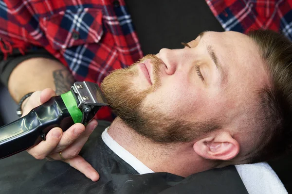 Baard verzorging. man terwijl zijn gezichtshaar te trimmen op de barbershop gesneden — Stockfoto