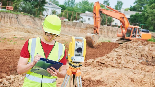 Geodeta pracownika z Teodolitem placu budowy — Zdjęcie stockowe