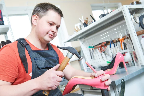 Shoemaker opravit ženské špice boty. Zatloukání tip na patě — Stock fotografie