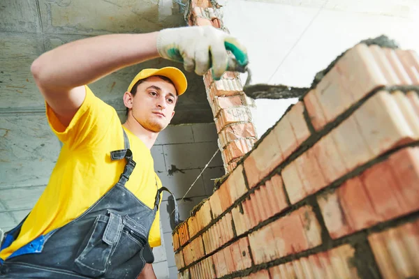 Albañilería. Obrero de la construcción construyendo una pared de ladrillo — Foto de Stock