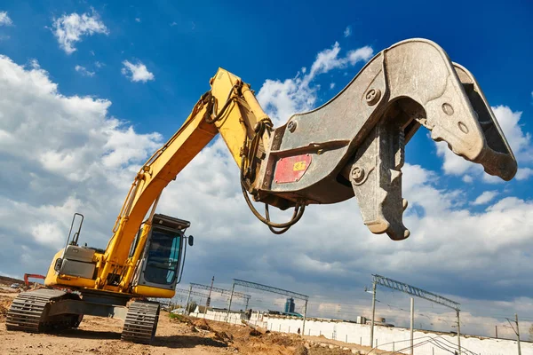 Excavatrice machine de concassage avec mâchoires écrasantes à la démolition sur le chantier de construction — Photo