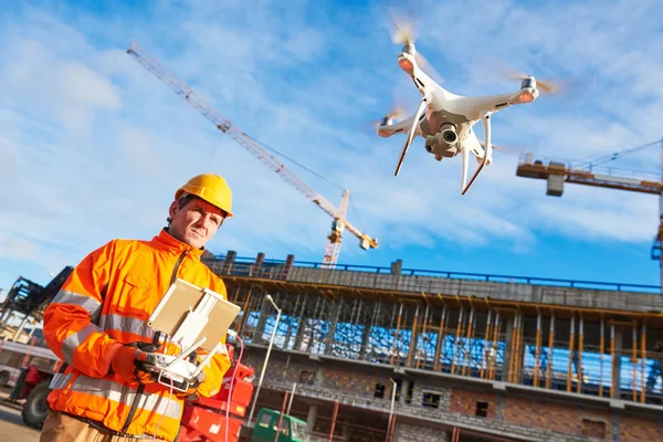 Drone obsługiwany przez pracownika budowlanego na placu budowy — Zdjęcie stockowe