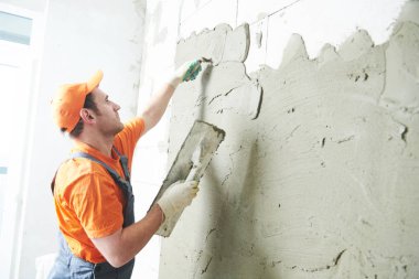 Evde tadilat. Sıvacı sıva duvar yaymak.