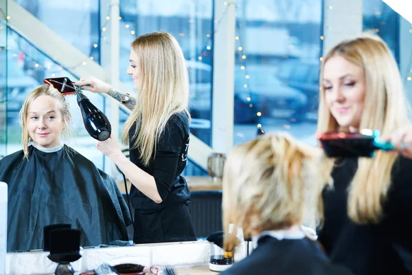 Barbeiro fêmea com secador de cabelo fazendo corte de cabelo masculino . — Fotografia de Stock