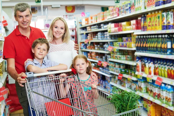 家庭购物。有孩子的父母和购物车在超级市场商店 — 图库照片