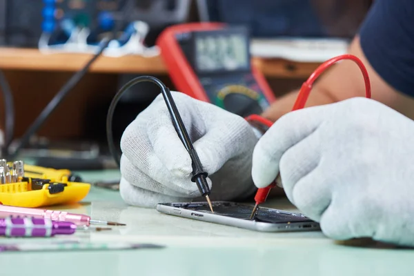 Smart phone repair. repairman testing electric circuit — Stock Photo, Image