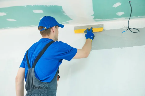 Refurbishment. Plasterer worker spackling a wall with putty — Stock Photo, Image