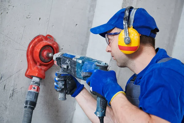 Electrician at work. boring hole for electric outlet by power tool drill. — Stock Photo, Image