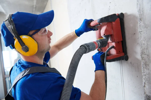 Elektricien op het werk. snijden van betonnen wand voor bekabeling door diamond snij machine — Stockfoto