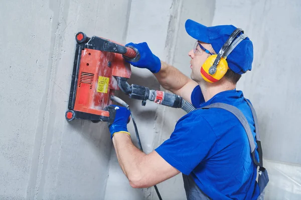 Elektricien op het werk. snijden van betonnen wand voor bekabeling door diamond snij machine — Stockfoto
