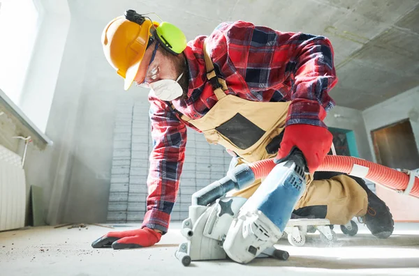 İnşaatçı iş başında. Elmas kesme makinesiyle kablo kesmek için beton zemin — Stok fotoğraf