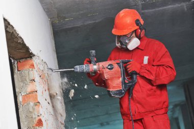 Yıkıcı çekiçli işçi iç duvarı yıkıyor.