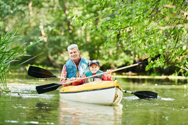 在森林里的河上划独木舟。家庭在独木舟上。活动休闲度假 — 图库照片