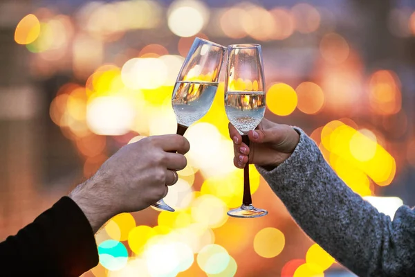 Manos masculinas y femeninas con copas de vino sobre la luz nocturna de la ciudad —  Fotos de Stock