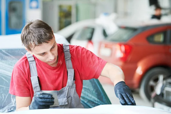 Auto repairman plastering autobody bonnet — Stock Photo, Image