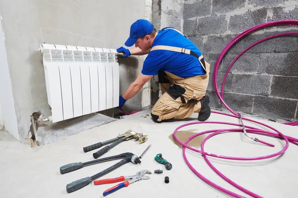 Plumber at work. Installing water heating radiator — Stock Photo, Image