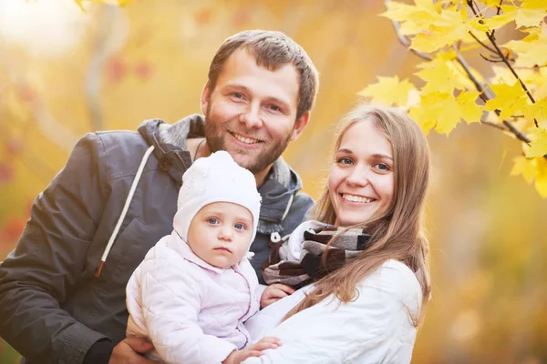 幸福的年轻家庭的画像与女婴在秋天公园 — 图库照片