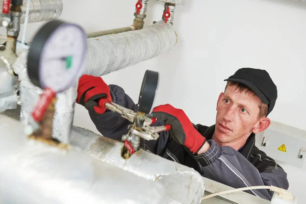 Ingegnere di riscaldamento o idraulico in locale caldaia installazione o regolazione manometro — Foto Stock
