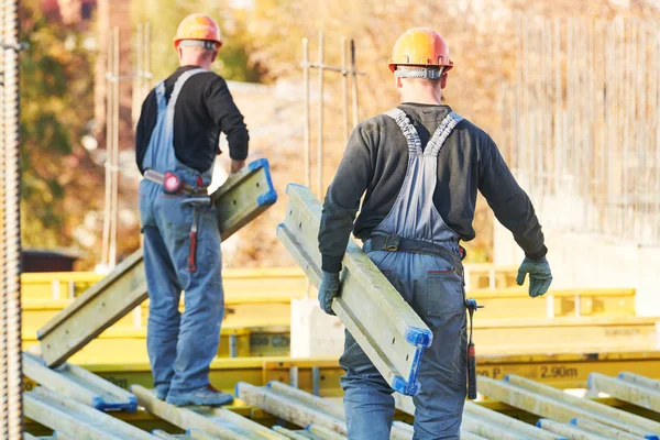 Trabajadores de la construcción en el área de construcción instalando gusanos —  Fotos de Stock