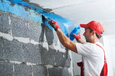 Sıva işçisi köşeleri örgü ile koruyor. inşa teknolojisi