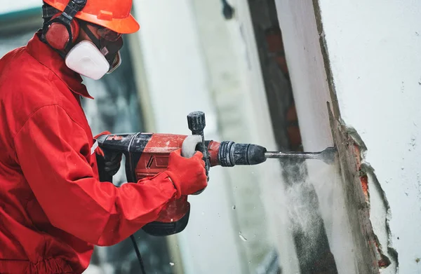 Travailleur avec marteau de démolition enlever le plâtre ou le stuc du mur — Photo