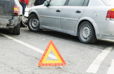 Kaza ya da gürültüyle çarpmak ile iki otomobil. Yol uyarı üçgen işaretini odak