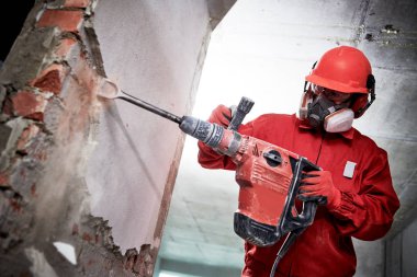 Demolition and construction destroying. worker with hammer breaking interior wall plastering clipart