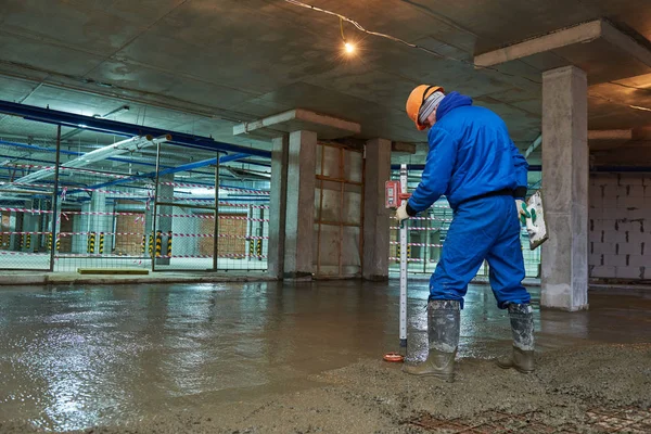 Bouw van de betonvloer. Werknemer met lijn — Stockfoto