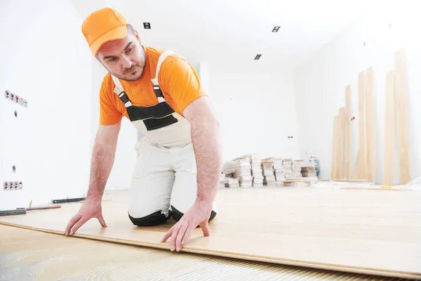 Trabajador uniéndose al suelo de parquet . — Foto de Stock