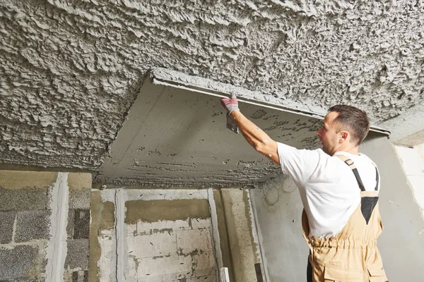 Gipser glättet Putzmörtel an der Decke mit Estrich — Stockfoto