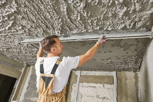 Gipser glättet Putzmörtel an der Decke mit Estrich — Stockfoto