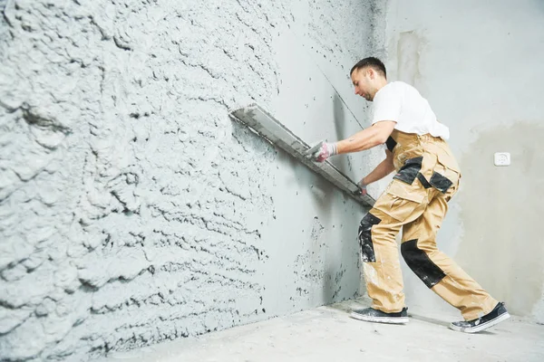 Putzer mit Estrich glättet Spachtelmörtel an Wand — Stockfoto